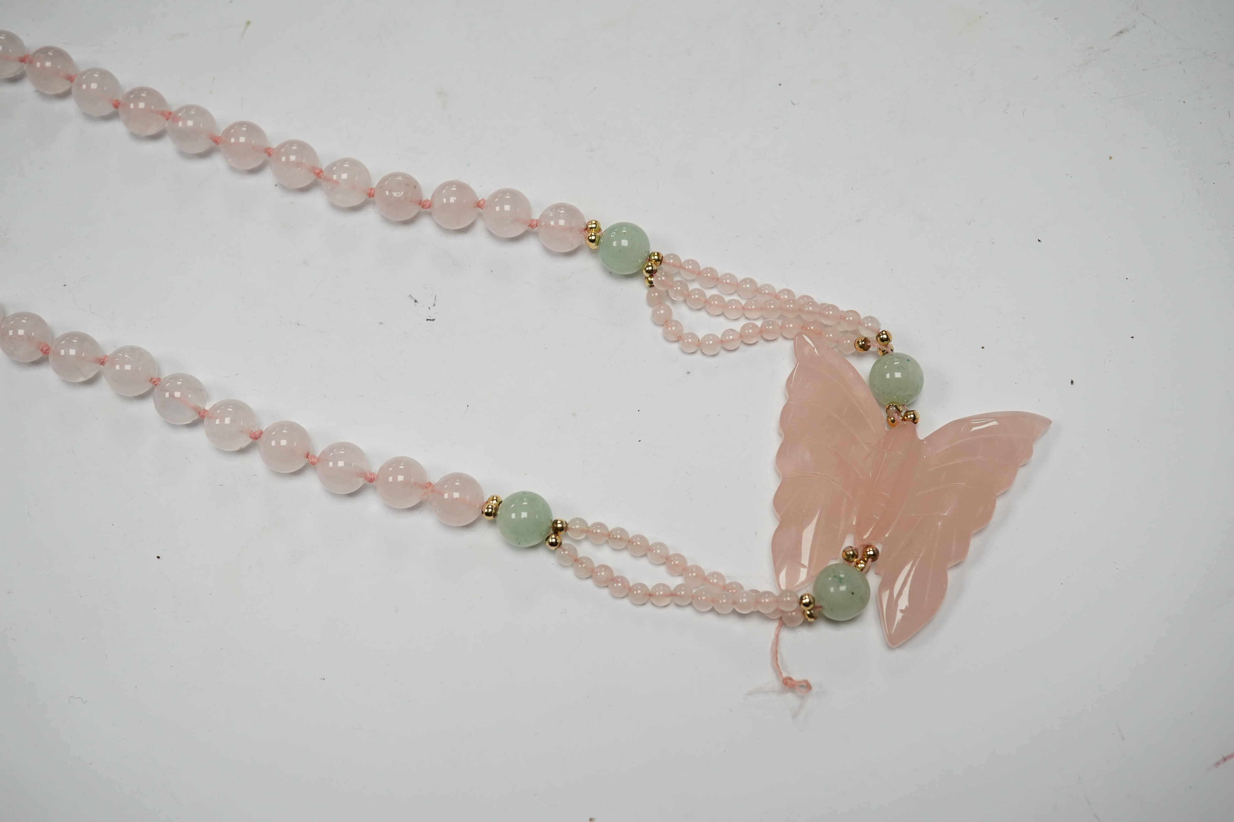 A recent rose quartz bead necklace, with central rose quartz butterfly and yellow metal and green quartz bead spacers, approx. 90cm. Condition - fair to good